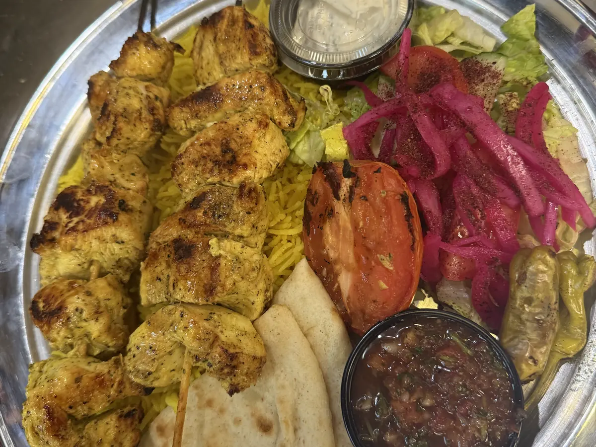 Chicken Adana platter at Kaboblicious: skewered chicken kabobs over rice with warm pita, white sauce, vinegar onions and a roasted tomato