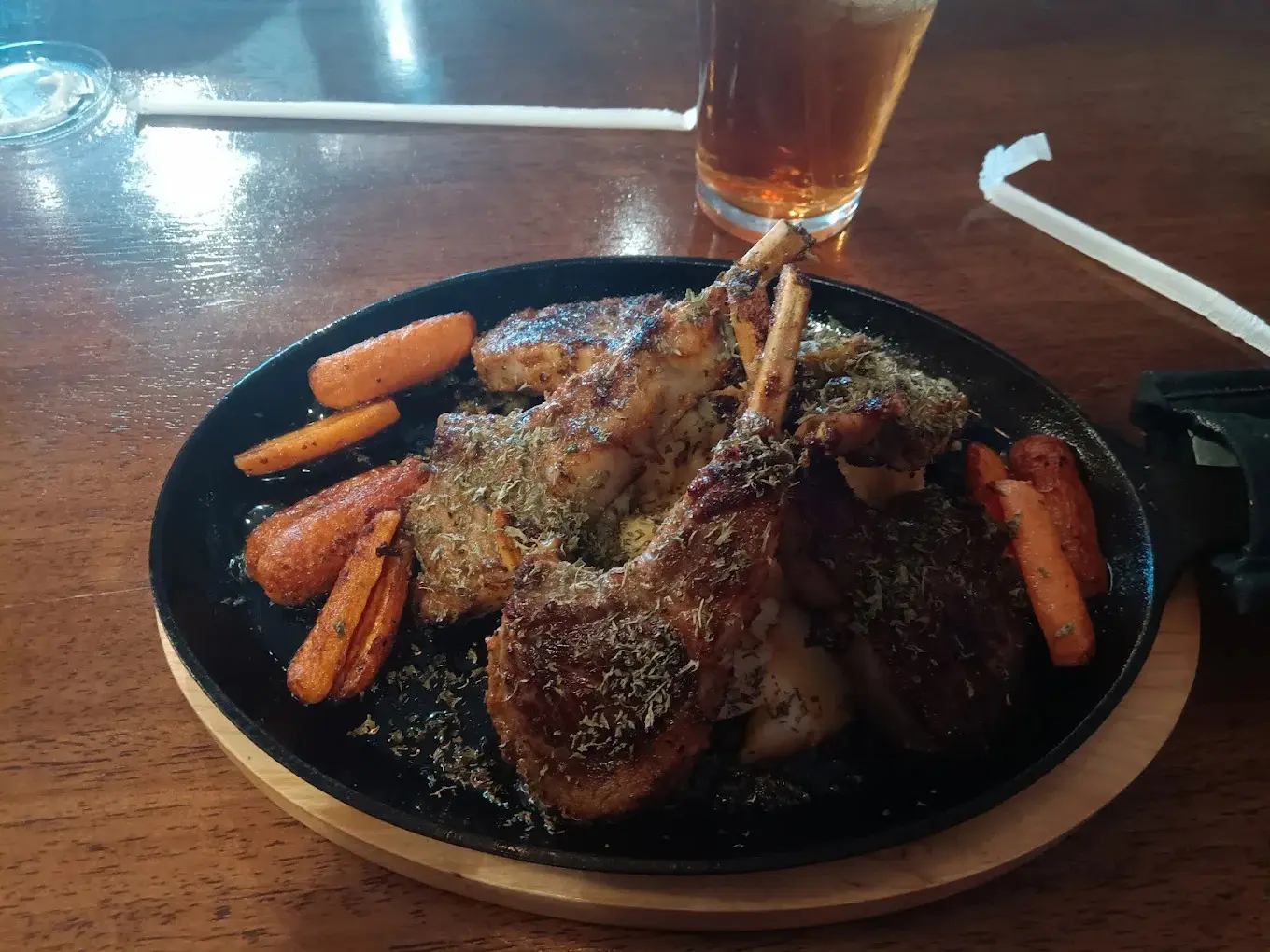 Grilled lamb chops on a cast iron skillet with seasoned carrots at Kaboblicious